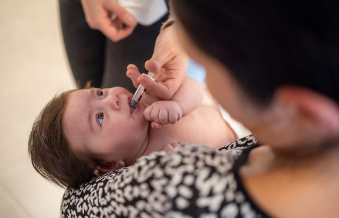 Een baby krijgt een oraal toegediend vaccin in het consultatiebureau