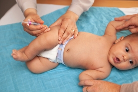 Een baby wordt gevaccineerd in het bovenbeen op het consultatiebureau