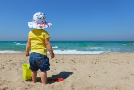 Een kind speelt op het strand