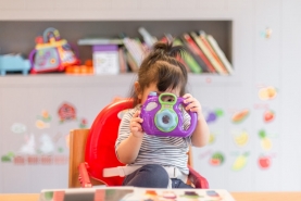 Kindje neemt foto met speelgoedcamera