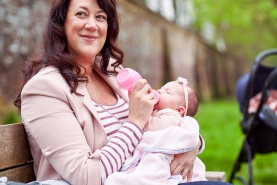 Mama geeft flesvoeding op bankje in het park