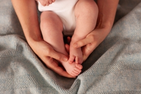 babyvoeten in handen omhelsing