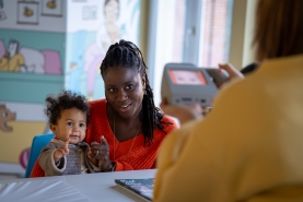 Kind doet oogtest bij mama op de schoot door verpleegkundige in Kind en Gezin Consultatiebureau