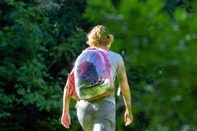 Studente wandelt met rugzak in het groen