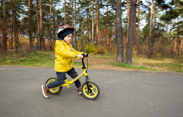 Kind speelt met loopfiets