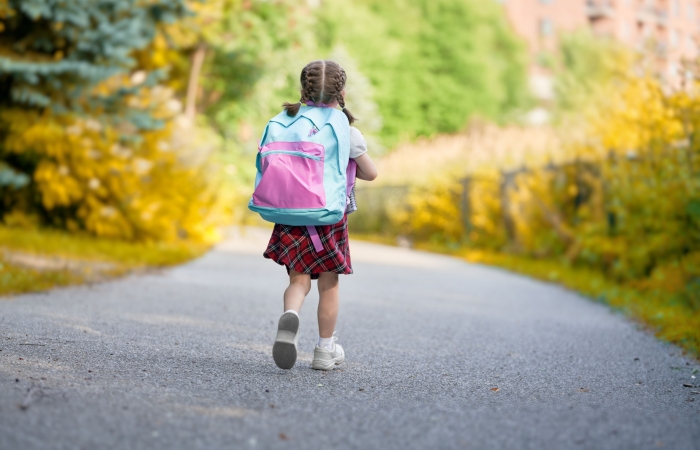 Meisje wandelt naar school met rugzak