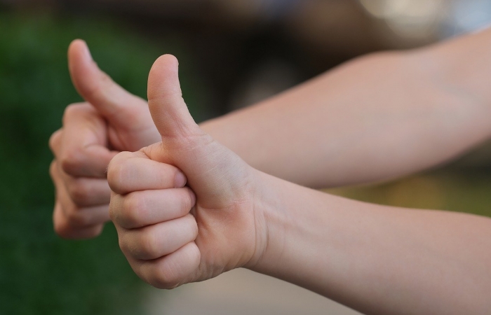 2 kinderarmen met duimen omhoog.