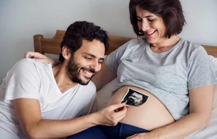 papa houdt echografie boven zwangere buik van mama