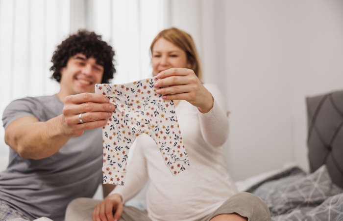 koppel kijkt naar babykleertjes