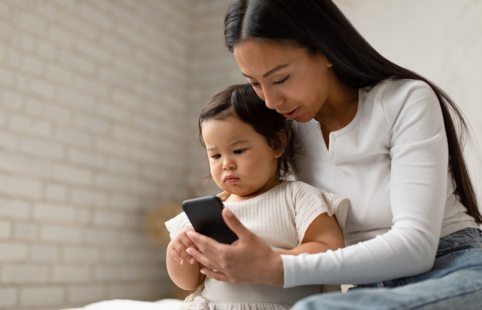 Peuter speelt samen met moeder op smartphone