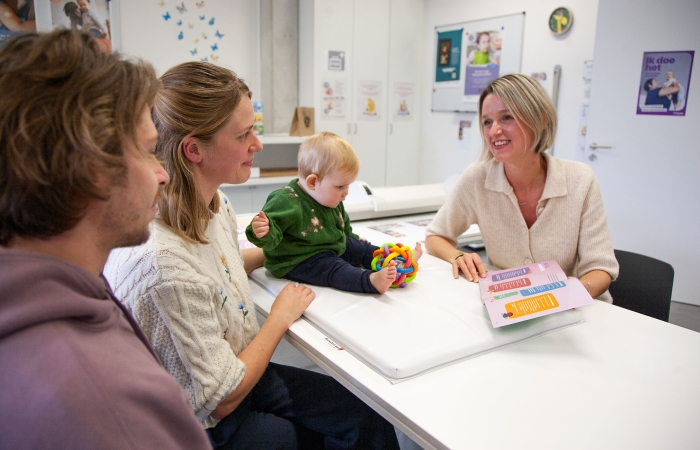 Baby en ouders met verpleegkundige op het consultatiebureau
