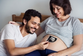 papa houdt echografie boven zwangere buik van mama