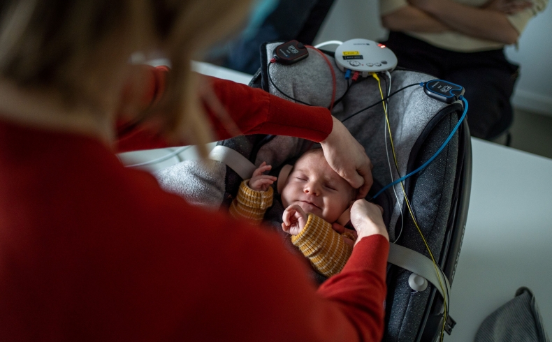 Verpleegkundige plaatst de gehoortest op baby