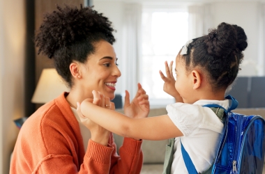 Moeder en dochter geven high five voor ze vertrekken naar school