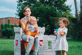 Greet, Millie en Gus blazen bellen in de tuin. Mama speelt met kinderen in de tuin, bellenblazen, kinderen met beperking blazen belletjes met mama