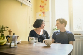 Een jong koppel in gesprek aan de keukentafel