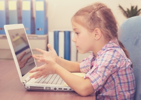 Foto van meisje dat geïrriteerd is omdat computer niet werkt