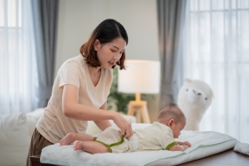 mama verzorgt baby op het verzorgingskussen
