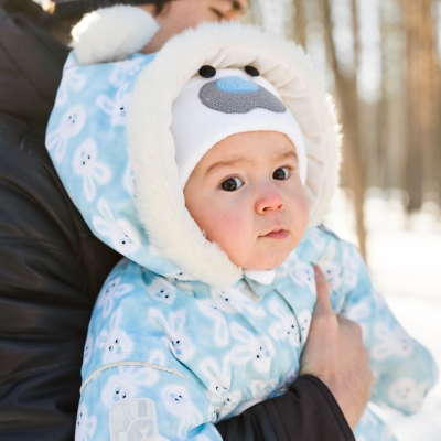 Baby ingeduffeld in winterjas in sneeuwlandschap