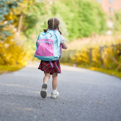 Meisje wandelt naar school met rugzak
