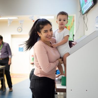 Een mama kleedt haar peuter om op het consultatiebureau