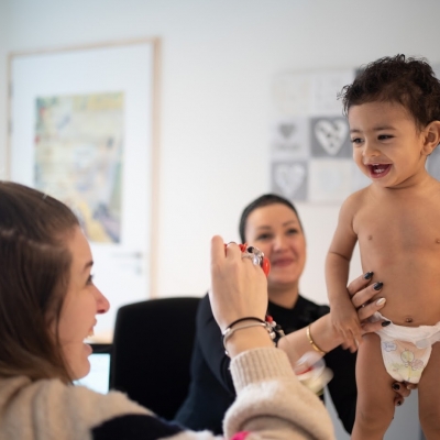 verpleegkundige in consultatiebureau geeft een speelgoedje aan peuter