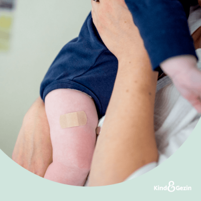 ouder houdt kind vast op de arm na vaccinatie op consultatiebureau