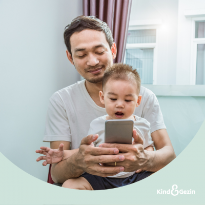 papa op smartphone met baby