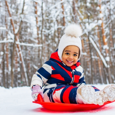 kind op slede in sneeuw winter