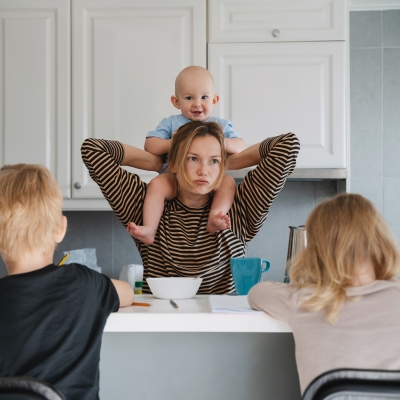 mama met baby op haar schouder en twee peuters