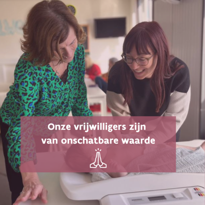 Vrijwilliger weegt baby, mama staat er bij 