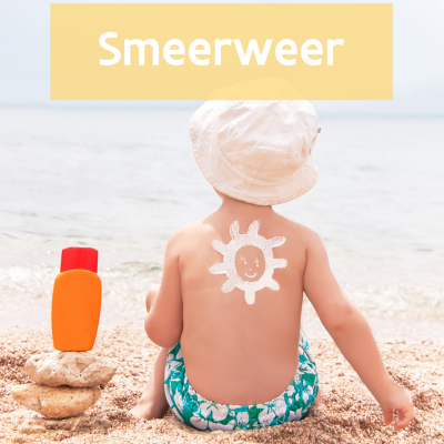 kind op het strand met een zonnetje in zonnecrème op zijn rug