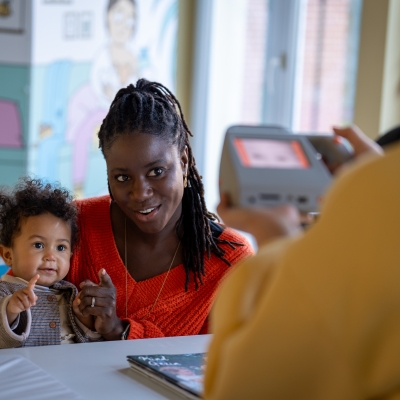 Kind doet oogtest bij mama op de schoot door verpleegkundige in Kind en Gezin Consultatiebureau