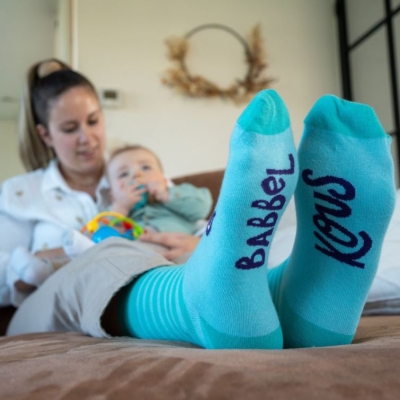 Taalstimulering, mama in de zetel met baby en babbelkousen