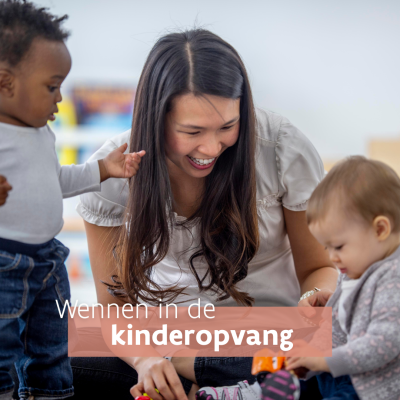 Lachende kinderbegeleider speelt met kinderen in de opvang