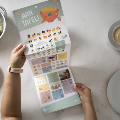 dame houdt wijzer vast omringd door potjes vaste voeding