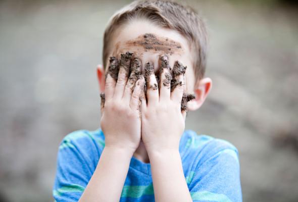 Een jongen maakt zich vuil tijdens het spelen in de natuur