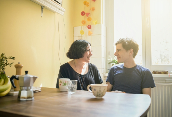 Een jong koppel in gesprek aan de keukentafel