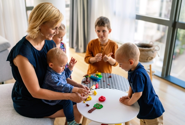 vrouw speelt met klei met peuter en kleuters vrouw speelt met klei met peuter en kleuters kinderbegeleider kinderopvang