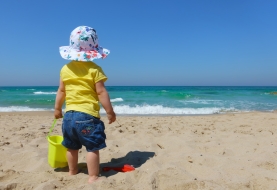 Een kind speelt op het strand