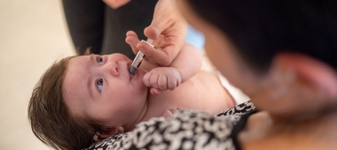 Een baby krijgt een oraal toegediend vaccin in het consultatiebureau