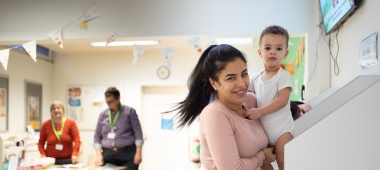 Een mama kleedt haar peuter om op het consultatiebureau