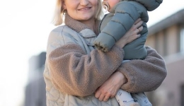 veilig op stap, mama houdt zoon vast, wandelen in de herfst of voorjaar, mama met kind op de arm