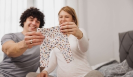 koppel kijkt naar babykleertjes