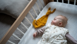 baby slaapt in slaapzak met knuffeldoekje